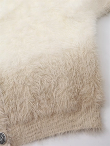Détail d'un cardigan dégradé duveteux avec bouton argenté vintage et ourlet en maille côtelée