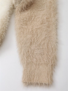 Détail des poignets côtelés sur un cardigan en maille beige doux à fils longs