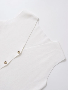 Dettaglio dello scollo a V e bottoni testurizzati su un gilet in maglia bianco
