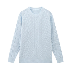 Dettaglio della maglia a trecce celeste e dei polsini a coste su questo maglione lavorato