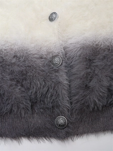 Détail d'un cardigan dégradé à texture duveteuse avec des boutons métalliques vintage ornés