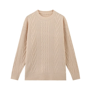 Dettaglio della classica trama a trecce e scollo rotondo a coste su un maglione beige
