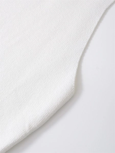 Dettaglio ravvicinato del tessuto a maglia bianco con finiture e cuciture di qualità