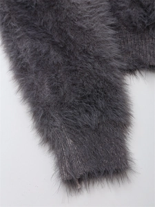 Détail du pull en mohair gris foncé avec poignets côtelés et texture douce et duveteuse