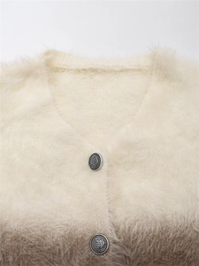 Détail des boutons en métal vintage sur un gilet en maille duveteuse avec dégradé