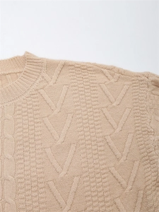 Dettaglio maglione beige a trecce con classici motivi a treccia e texture a forma di V