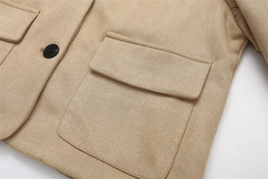 Detailed close-up of khaki faux suede short jacket with large pocket and black button