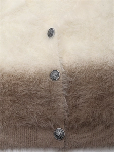 Gros plan du cardigan en maille dégradée avec des boutons métalliques gaufrés vintage