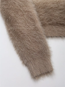 Détail d'un pull en maille mohair marron montrant la texture pelucheuse et les poignets