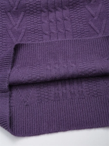 Dettaglio ravvicinato di maglione viola a trecce con trama a coste e tessuto morbido