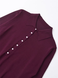 Détail du polo en maille violette avec col classique et boutons blancs décoratifs