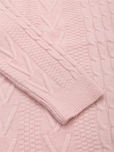 Dettaglio della trama a treccia rosa e dei polsini a coste sul maglione girocollo
