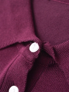 Gros plan détaillé sur la texture tricotée violet foncé et les boutons blancs pour femmes