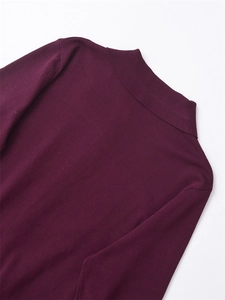 Détail du pull en tricot bordeaux montrant le col montant et la texture de la couture