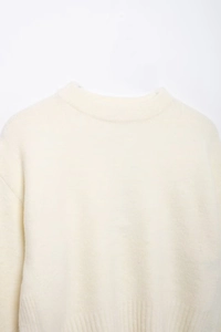 Détail du col rond et de la texture douce et pelucheuse de ce pull en maille blanc