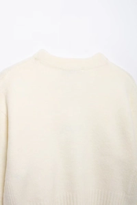Détail du col rond et de la maille douce sur ce pull d'hiver pour femme blanc crème