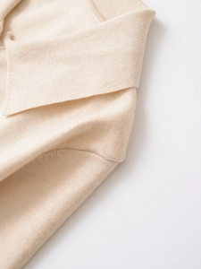 Dettaglio polo in maglia beige con trama fine in cashmere e colletto a rever rifinito