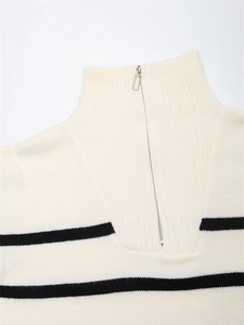 Détail du col d'un pull rayé beige avec fermeture éclair argentée et texture en maille