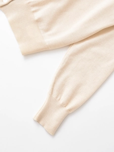 Dettaglio dei polsini e dell'orlo in maglia a coste su un maglione di cashmere crema