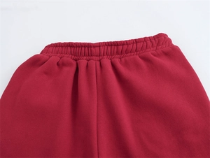 Dettaglio dei jogger rossi con elastico in vita rinforzato e morbida texture in pile