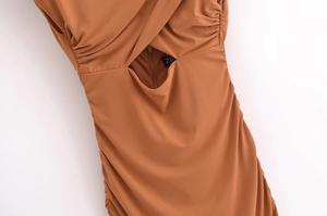 Detail of the brown slim-fit dress featuring a crisscross neckline and waist cutout detail