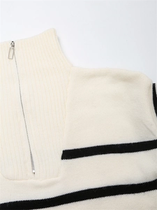 Détail de la fermeture éclair en argent et du col roulé sur le pull en tricot rayé