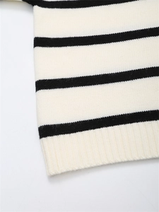 Vue macro d'un pull en maille rayé noir et blanc montrant les détails de l'ourlet côtelé