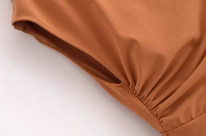 Detail of caramel orange dress showing fine fabric texture and pleated shoulder seams
