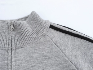 Détail du cardigan en maille gris clair avec demi-fermeture éclair et rayures aux épaules