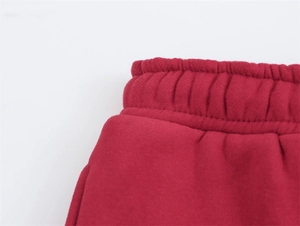 Dettaglio dei pantaloni sportivi bordeaux con elastico in vita e trama del tessuto