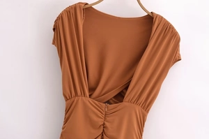 Detail of the open back design with ruching and hidden zipper on caramel slim dress
