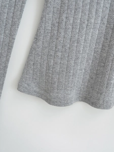 Gros plan détaillé sur un tissu en maille côtelée gris clair avec motifs dentelle