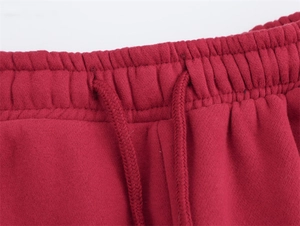 Dettaglio macro della fascia elastica in vita con coulisse sui pantaloni sportivi rossi