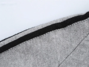 Macro d'un tissu tricoté gris avec détail de rayure noire sur le pull pour femme