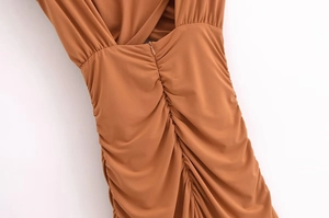 Close-up of ruched back detail and invisible zipper on caramel slim-fit dress