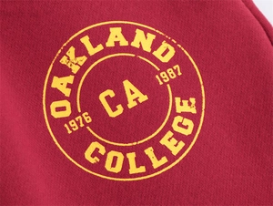 Dettaglio in maglia bordeaux con stampa grafica vintage Oakland College gialla