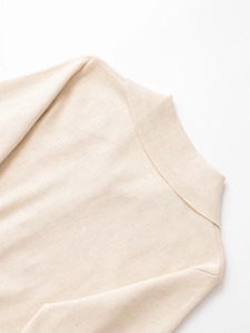 Dettaglio dello scollo polo in cashmere crema con trama a maglia fine e cuciture curate