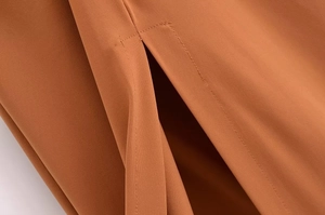 Close-up of caramel backless dress showing refined slit detail and durable stitching
