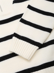 Détail d'un pull en maille rayé noir et blanc avec poignets côtelés et fermeture éclair