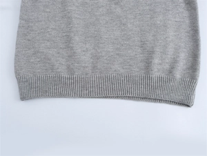Détail de l'ourlet côtelé sur un pull en maille gris classique pour femme