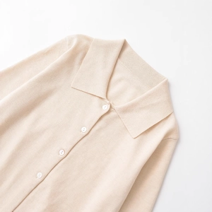Polo da donna in maglia beige con colletto classico e bottoni bianchi minimalisti