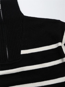 Détail du col demi-zippé et du zip en métal sur le pull en tricot à rayures