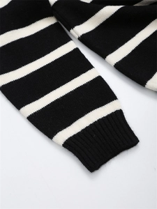 Détail de la manche d'un pull rayé noir et blanc avec finition poignet côtelée