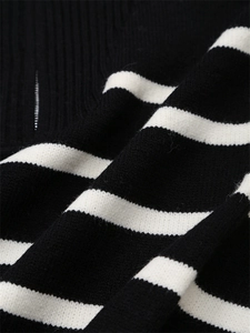 Vue détaillée de la maille rayée noire et blanche et de la fermeture éclair en métal