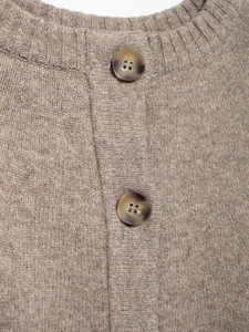 Close-up of oatmeal knit cardigan with ribbed collar and dark tortoiseshell buttons
