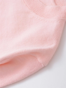 Close-up of the delicate ribbed neckline and soft knit texture of the pink cashmere sweater