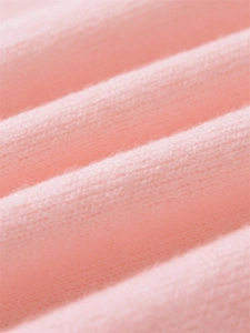 Detailed close-up of soft pink knit fabric texture showing premium stitching quality