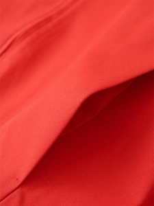 Dettaglio ravvicinato del tessuto twill rosso e cuciture pulite sulla tasca del bomber