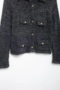 Détail du cardigan en maille gris foncé avec texture épaisse et boutons dorés