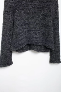 Gros plan détaillé de l'ourlet du cardigan en tricot gris foncé à texture pelucheuse